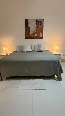 a bedroom with a green bed with two lamps at Soho loft residence in Santo Domingo