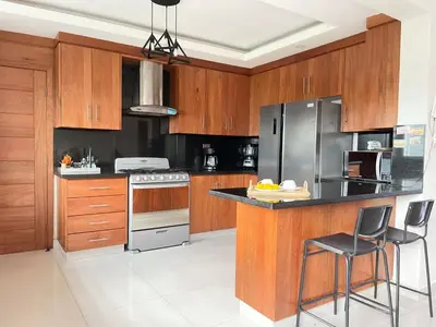a kitchen with wooden cabinets and stainless steel appliances at Confortable apartamento a 10 min del aeropuerto in La Viva