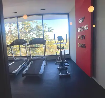 a gym with three tread machines and a large window at Apto céntrico con piscina, gym y una hermosa vista a la ciudad in Santo Domingo