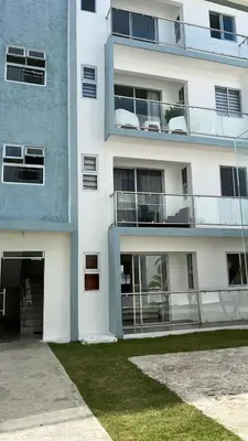 a white apartment building with a parking garage at Cozy Tropical Getaway in Los Altos de Jalisco