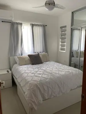 a bedroom with a white bed with a ceiling fan at Cozy Tropical Getaway in Los Altos de Jalisco