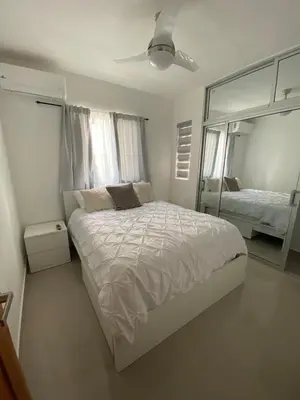 a white bedroom with a large bed and a mirror at Cozy Tropical Getaway in Los Altos de Jalisco