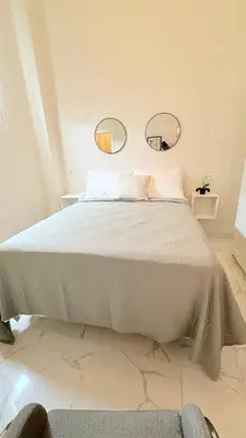 a bedroom with a large bed with two mirrors on the wall at Exclusive Soho Loft Residence in Santo Domingo
