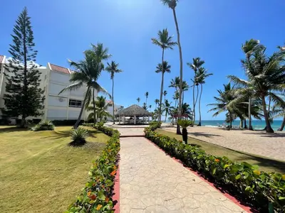 a walkway next to a beach with palm trees at Vista marina apartment in Villas del Mar