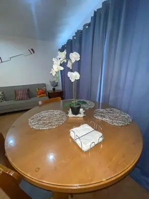 a wooden table with a vase with white flowers on it at Vista marina apartment in Villas del Mar