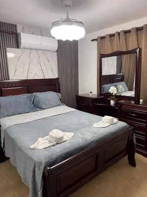 a bedroom with a bed with two hats on it at Acogedor y céntrico apartamento en Palmas de Gurabo in Santiago de los Caballeros