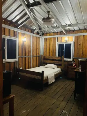 a bedroom with a bed in a room with wooden walls at Villa de Grupo 16, Piscina Natural, Jacuzzi, Granja y Mascotas, Rosa & Deivi te esperan in Villa Altagracia