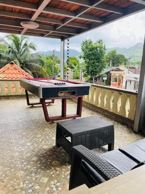 a ping pong table on a patio with a pool table at Villa de Grupo 16, Piscina Natural, Jacuzzi, Granja y Mascotas, Rosa & Deivi te esperan in Villa Altagracia