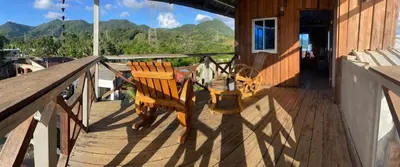 a balcony with a table and chairs on a house at Villa de Grupo 16, Piscina Natural, Jacuzzi, Granja y Mascotas, Rosa & Deivi te esperan in Villa Altagracia