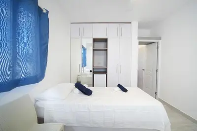 a white bedroom with two beds in a room at La casa del Maestro apartment in Bayahibe