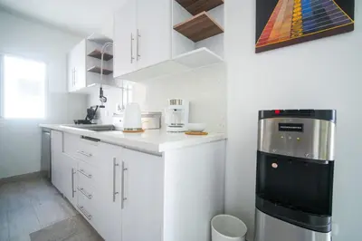a kitchen with white cabinets and a black appliance at La casa del Maestro apartment in Bayahibe