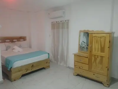 a bedroom with a bed and a dresser and a mirror at Home Realty in Santo Domingo
