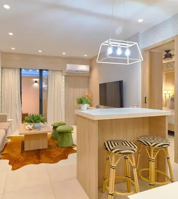 a living room with a kitchen with a bar and stools at ®{Peaceful~Retreat} @DowntownSD HotTubGymFamily in Santo Domingo