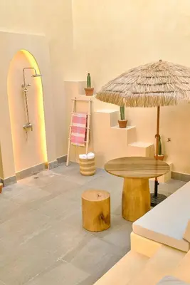 a room with a table and a umbrella and a stool at ®{Tulum~Experience}@Downtown PoolViewPenthouse in Santo Domingo