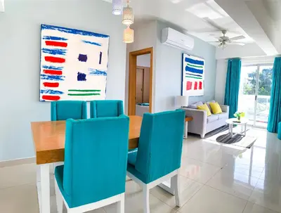 a dining room with a table and blue chairs at Apartamento en Boca Chica T1 302 in Boca Chica