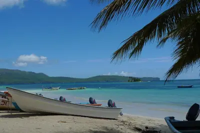 a boat sitting on the beach next to the water at Apart-Hotel Garden Villa in Las Galeras