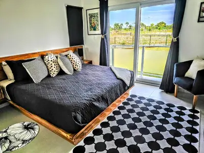 a bedroom with a bed with a window and a rug at NEW Luxury at Sosua Ocean Village Laguna City in Sosúa
