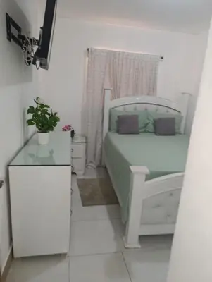 a small bedroom with a white bed and a window at Comfort, safety and close to everything in Los Paredones