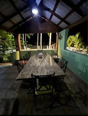 a large wooden table with chairs and a light on top at Emmanuel villas luxury in Puerto Plata