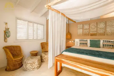 a bedroom with a bed and two chairs and a window at Mahona Boutique Hotel in Las Terrenas
