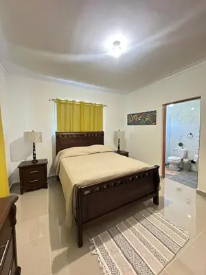 a bedroom with a large bed and a bathroom at Vista Azul Boca Chica Accommodation in El Higo