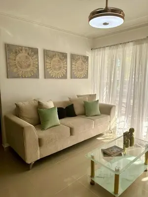 a living room with a couch and a glass table at Modern, Elegant & Comfortable Apartment in El Seis
