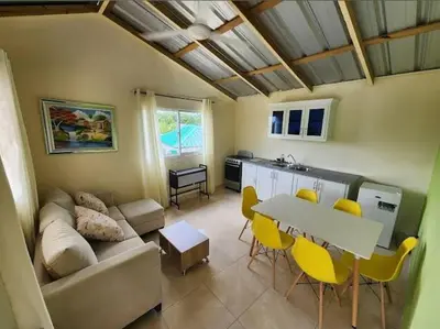a living room with a couch and a table and chairs at Villa Janel in Punta Rucia