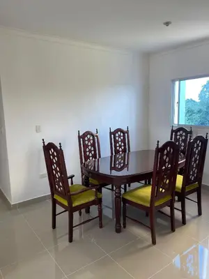 a dining room with a wooden table and chairs at Comodo apartamento en Boca Chica SDQ AILA in El Higo