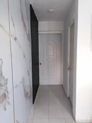a hallway with a white door and a white tile floor at Studio Apartment 5 - SML Garden in La Romana