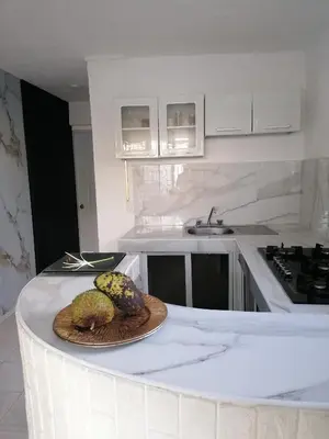 a white kitchen with a plate of fruit on a counter at Studio Apartment 5 - SML Garden in La Romana