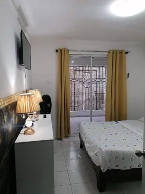 a bedroom with a bed and a desk and a window at Studio Apartment 5 - SML Garden in La Romana