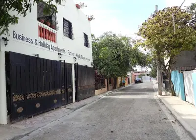 an empty street next to a building with a fence at Aparta hotel El Sol, Home near AirPort SDQ in Boca Chica