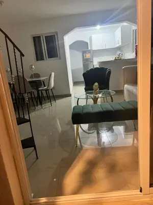 a living room with a chair and a table at Comodo y acogedor apartamento en Los Mameyes in Los Tres Ojos de Agua
