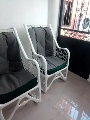 two white chairs sitting next to a window at Comodo y acogedor apartamento en Los Mameyes in Los Tres Ojos de Agua