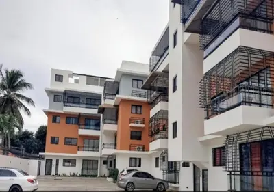 two cars parked in front of a building at Hermoso Apartamento de tres habitaciones in La Viva