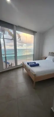 a bedroom with a bed with a view of the ocean at Hostel capicua in Punta Cana