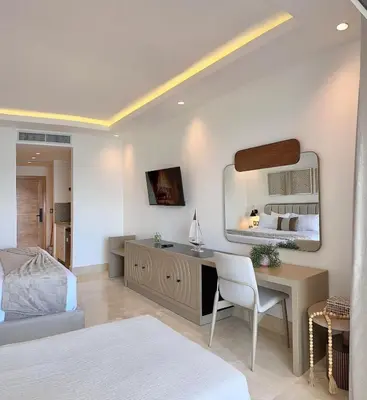 a bedroom with a bed and a desk with a mirror at Stylish Studio Samaná Bay View, Pool and Gym Access in Santa Bárbara de Samaná