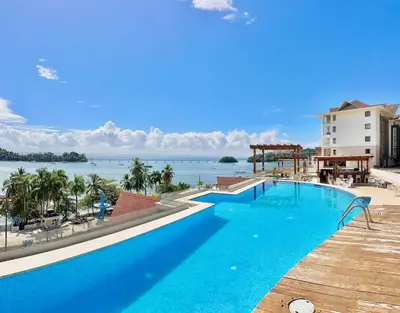 a large swimming pool with a view of the water at Stylish Studio Samaná Bay View, Pool and Gym Access in Santa Bárbara de Samaná