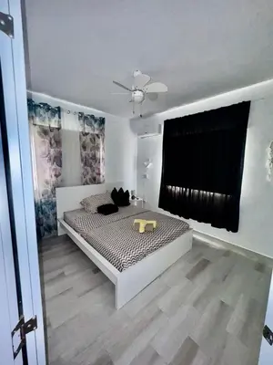 a bedroom with a bed and a ceiling fan at Le Camere Del Maestro in Bayahibe
