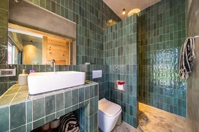 a green tiled bathroom with a sink and a toilet at REFUGIO Sabaneta de Yasica in Cabarete
