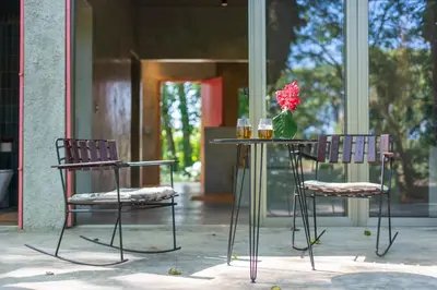 two chairs and a table with a vase of flowers at REFUGIO Sabaneta de Yasica in Cabarete