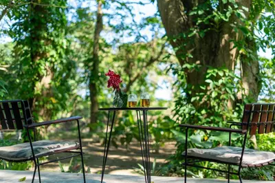a table with two chairs and a vase with a flower on it at REFUGIO Sabaneta de Yasica in Cabarete