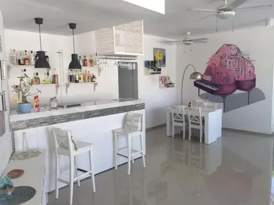 a kitchen with a counter and chairs in a room at Art Villa Dominicana in Punta Cana