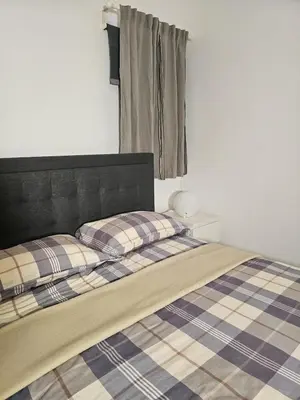 a bed with two pillows on it in a room at Luxury apartment in Santo Domingo Este in Juan López
