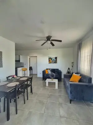 a living room with a blue couch and a ceiling fan at OMY Apartments Nagua 2A in Nagua