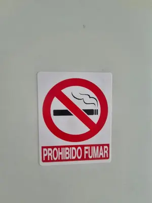 a sign on a wall with a no smoking sign at OMY Apartments Nagua 2A in Nagua