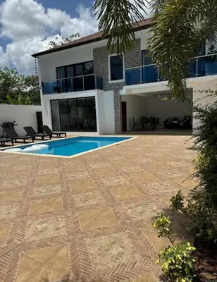 a villa with a swimming pool in front of a house at villas el guano in Sosúa