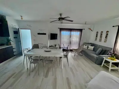 a living room with a table and a couch at Greta's Penthouse Bayahibe in Bayahibe