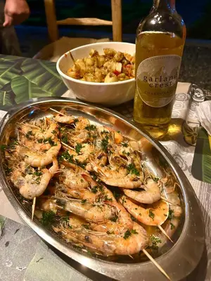 a plate of shrimp on a table with a bottle of beer at Villa KAMBUSA appartamento SOFIA in Las Galeras