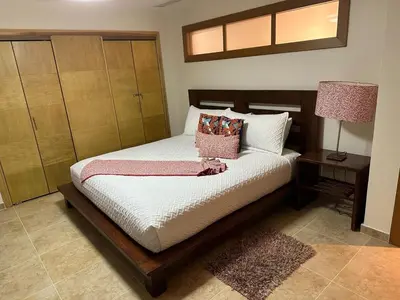 a bedroom with a bed with a night stand and a lamp at Juan Dolio Beach, Marbella Ocean Front in Colorado